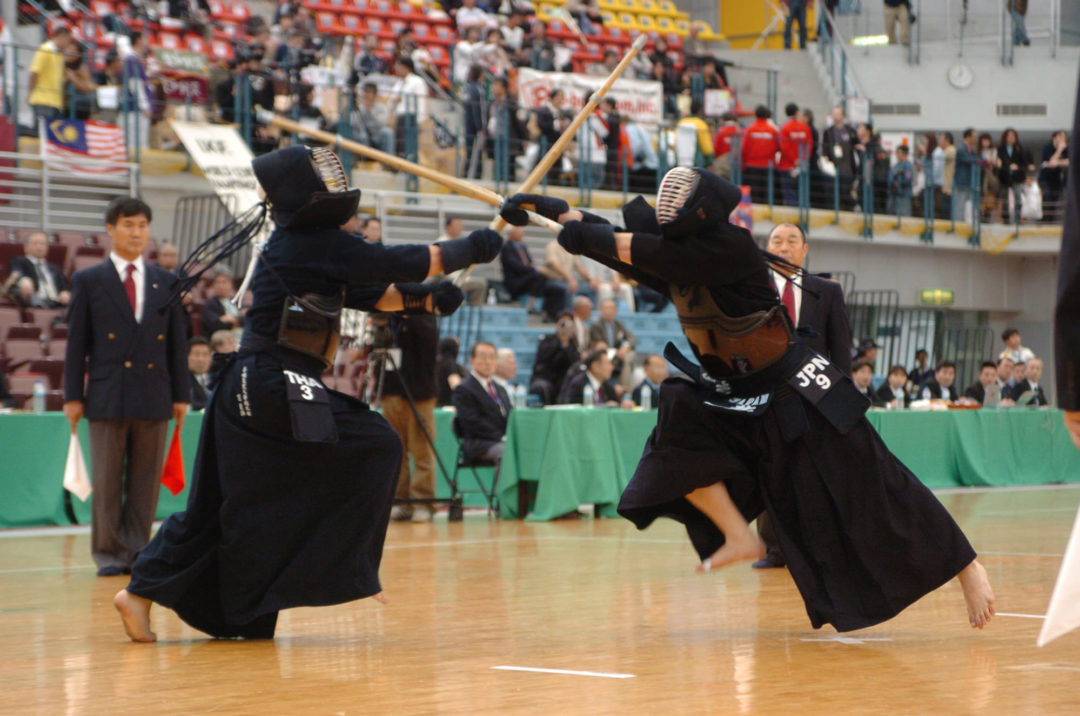 Two kenshi meet in a match, shinai crossed